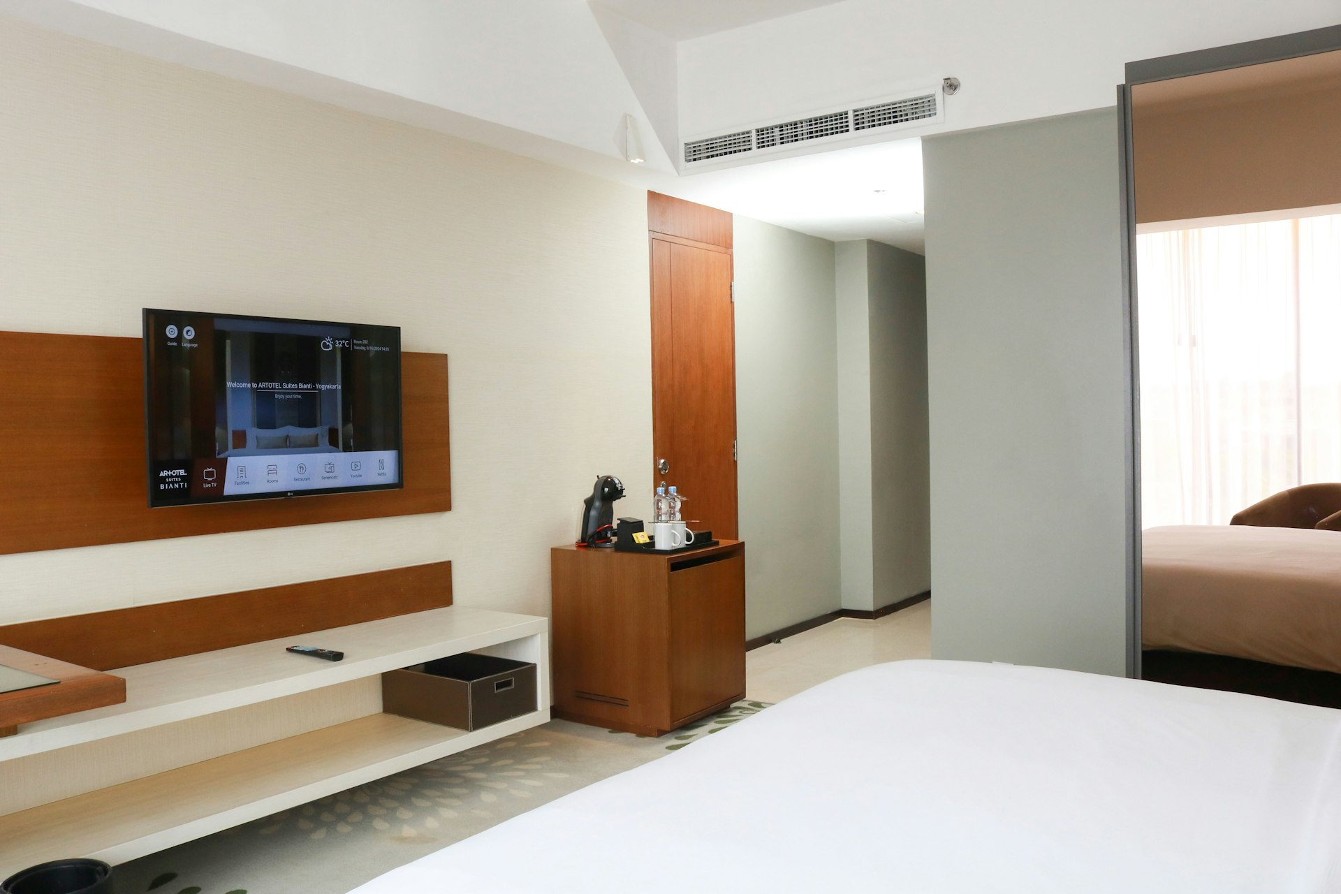 A hotel room with a bed, television, and desk